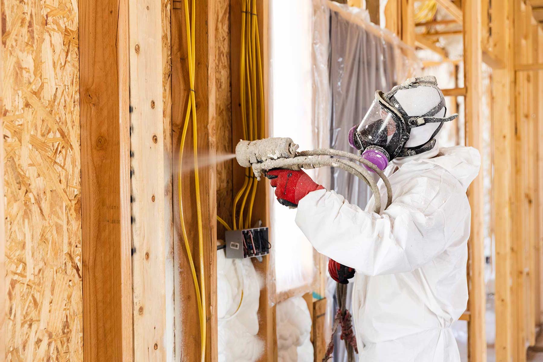 Spray foam insulation installer applying foam